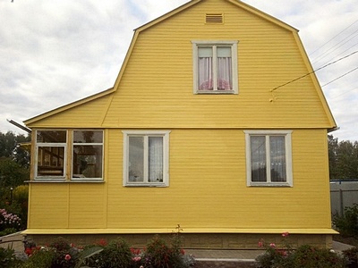 Перекраска деревянного дома снаружи фасадной краской в жёлтый цвет