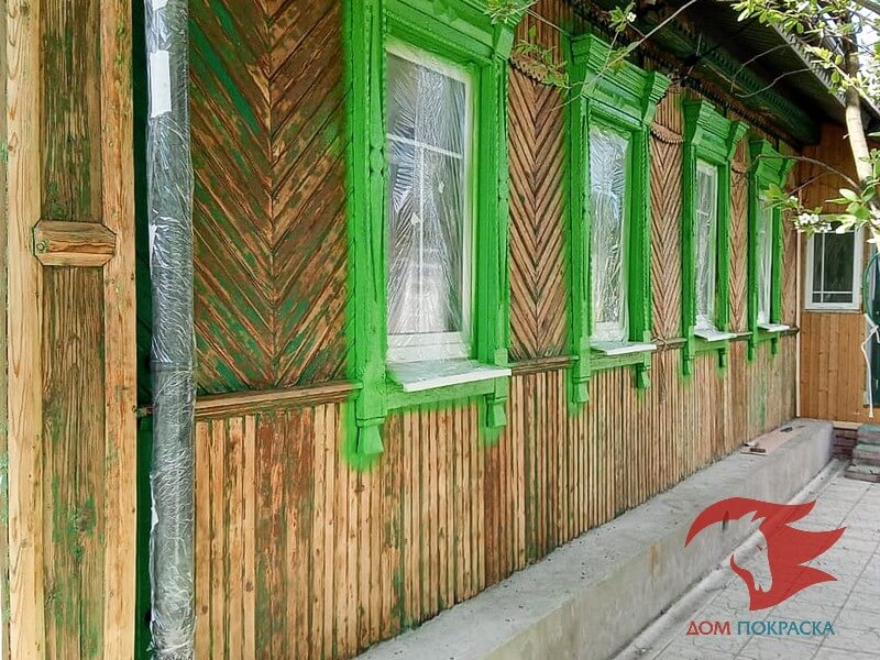 Процесс шлифовки старой краски на деревянном доме